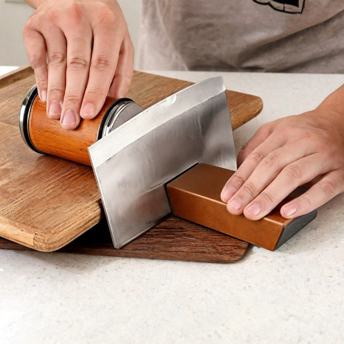A cleaver on the angle block with the roller raised on a cutting board so its disc reaches the edge